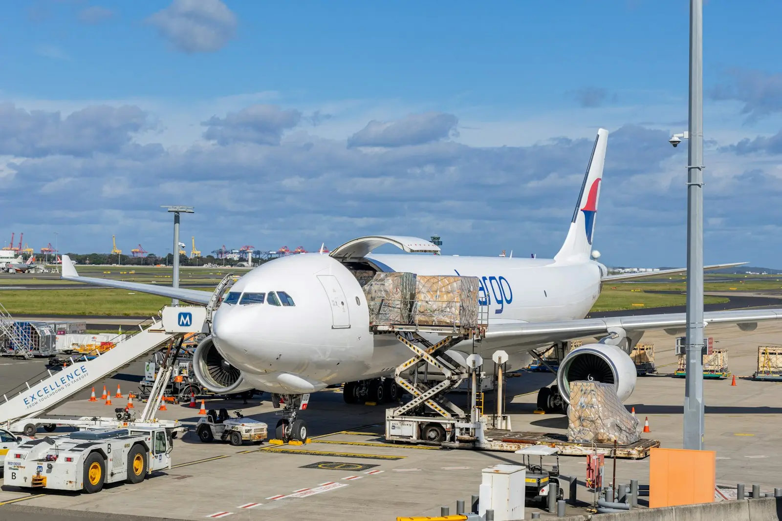 Freighter aircraft being loaded with cargo pallets on the apron
